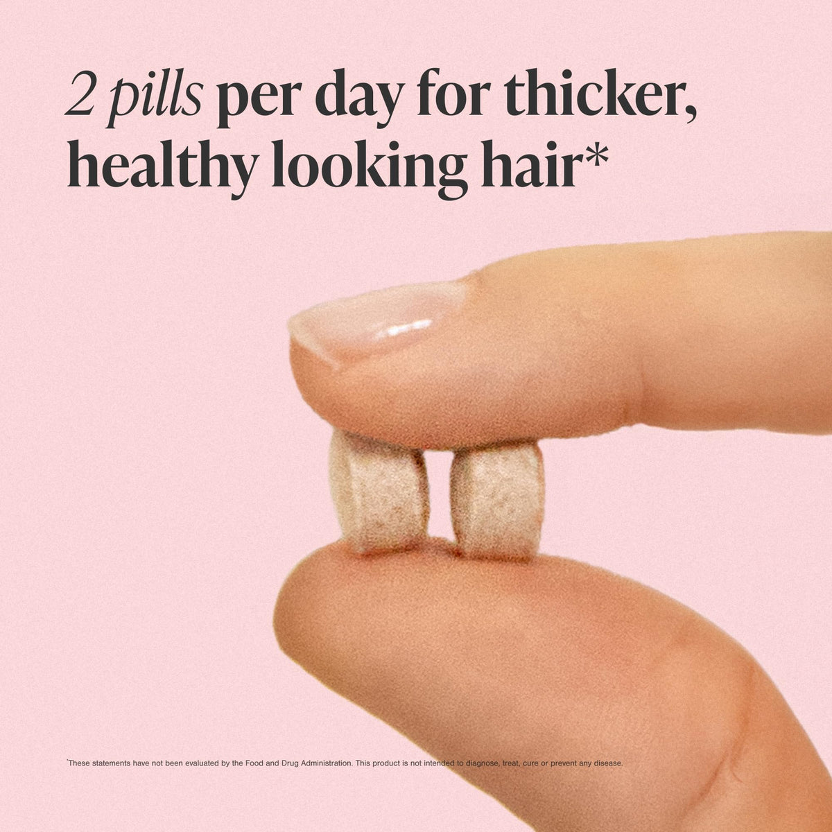 Viviscal tablets in hand for scale showing tablet size and ease of swallowing