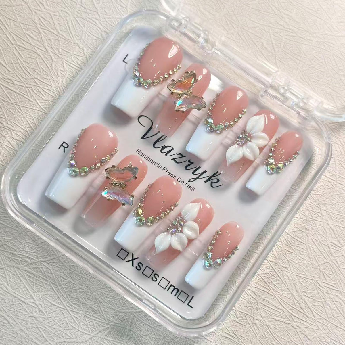 Vlazryk front packaging showing long square white French nails and luxurious presentation