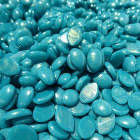 Tub of Waxness beside a hand for scale indicating generous 1 kg supply