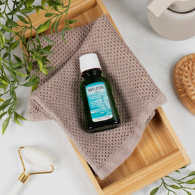 Weleda oil applied to dry hair ends demonstrating frizz control and added shine