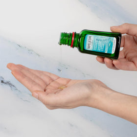 Weleda bottle held in hand for scale showing portable 1.7 fl oz size and travel convenience