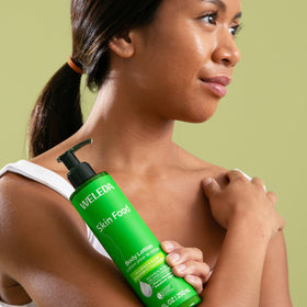 Weleda Skin Food body lotion applied on leg in bedroom for moisturizing results