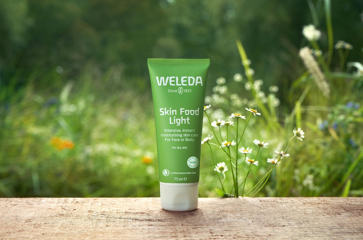 Weleda Skin Food Light tube in a purse illustrating portability and on-the-go benefit