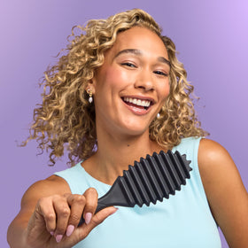 Wet Brush Curl Shaper scale next to a hand showing compact, portable dimensions
