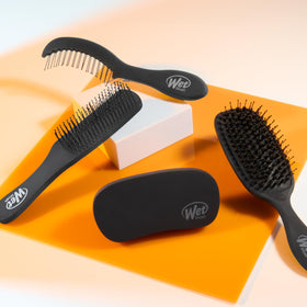 Wet Brush on bathroom vanity beside beard oil for quick daily touch-ups