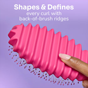 Wet Brush held in hand to show compact size and portability for travel