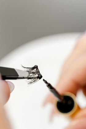 WinkClique glue being applied to cluster lashes illustrating easy DIY use