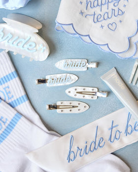 xo, Fetti close-up of blue cursive "bride" text on white acrylic highlighting elegant party-ready detail