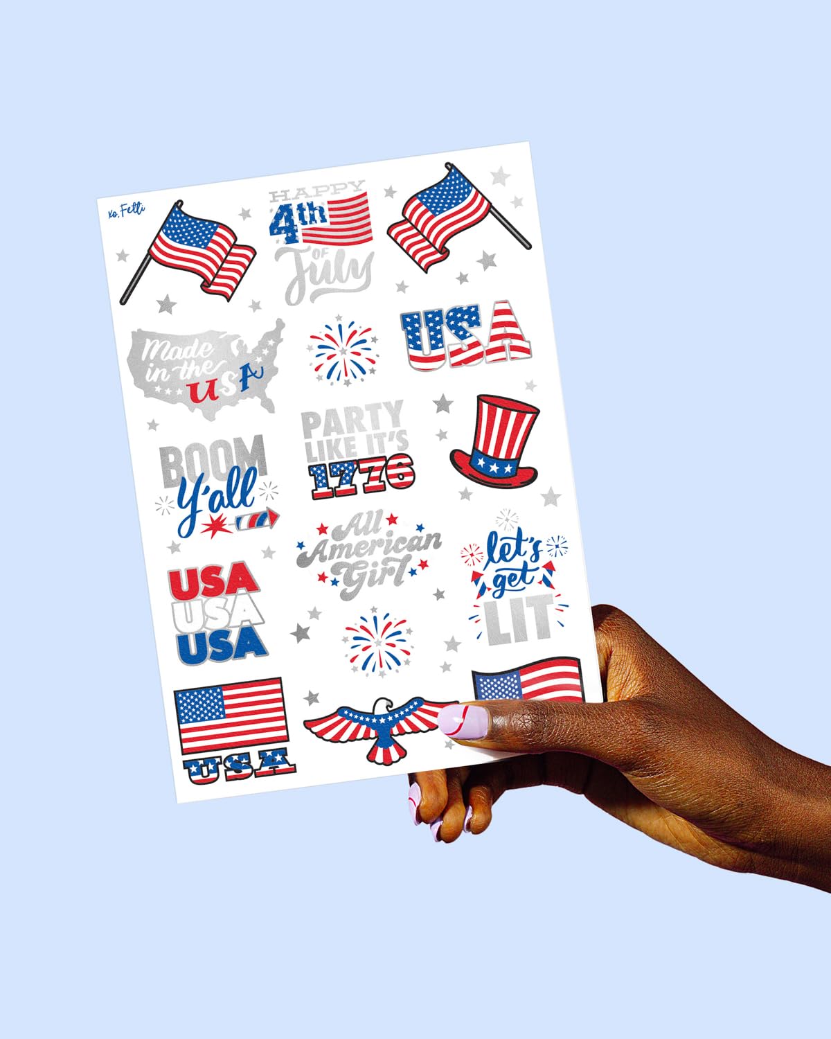 xo, Fetti tattoo sheet next to a hand to show scale and usable sizes