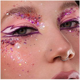 YGQQOY glittered festival attendee under lights demonstrating dramatic concert glow