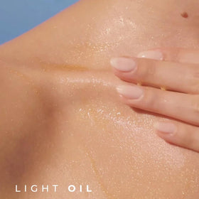 Close-up of pearly oil texture on hand, highlights quick absorption and luminous finish