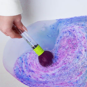 ZIMPLI bath bomb dissolving in tub, demonstrating vibrant colour change and safe fizz